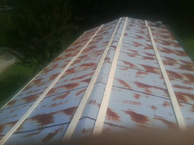 Rusted metal roof panels with new wood purlins before replacement — Storm Damage Roof Repair in Hyannis Port by Roofing Brothers