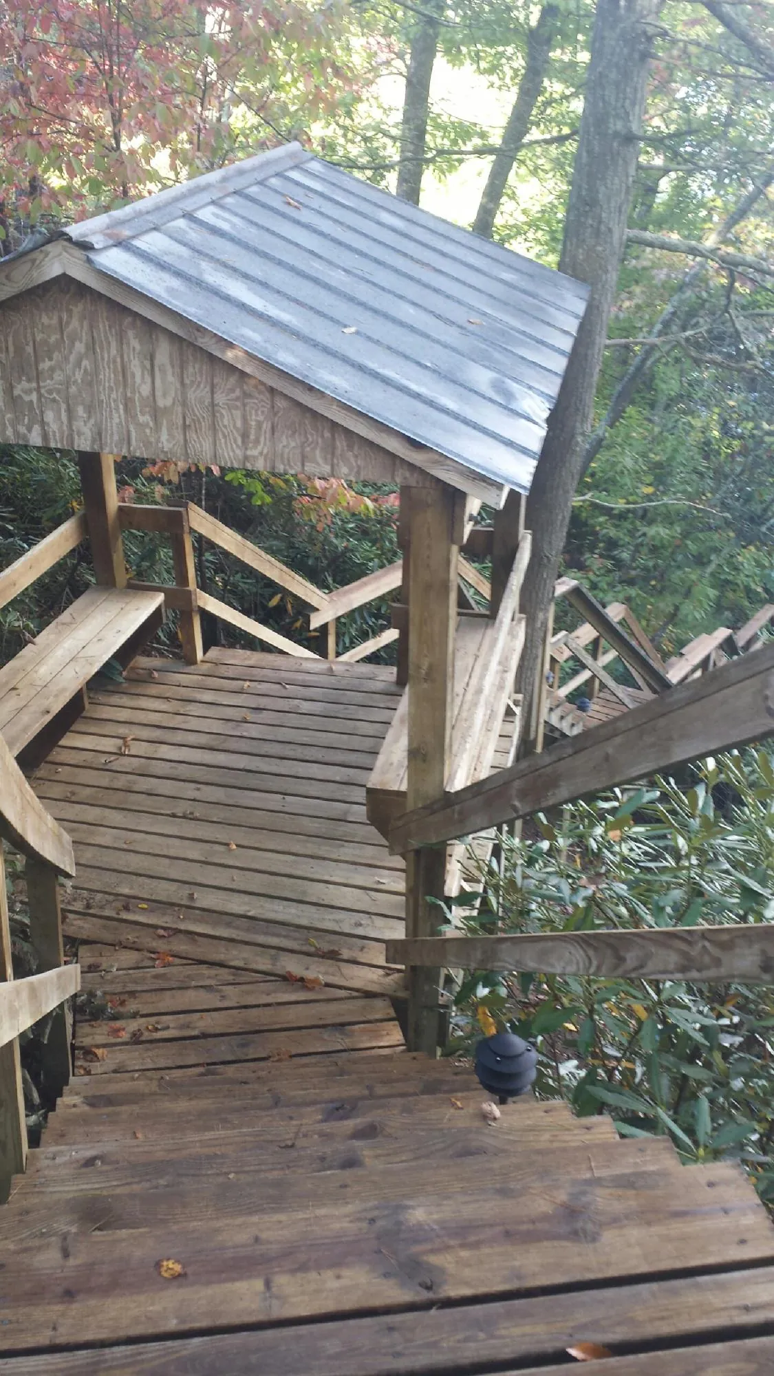 Metal roofed shelter over wooden steps on a wooded walkway — Skylight Repair & Installation work by our crew in Hyannis Port