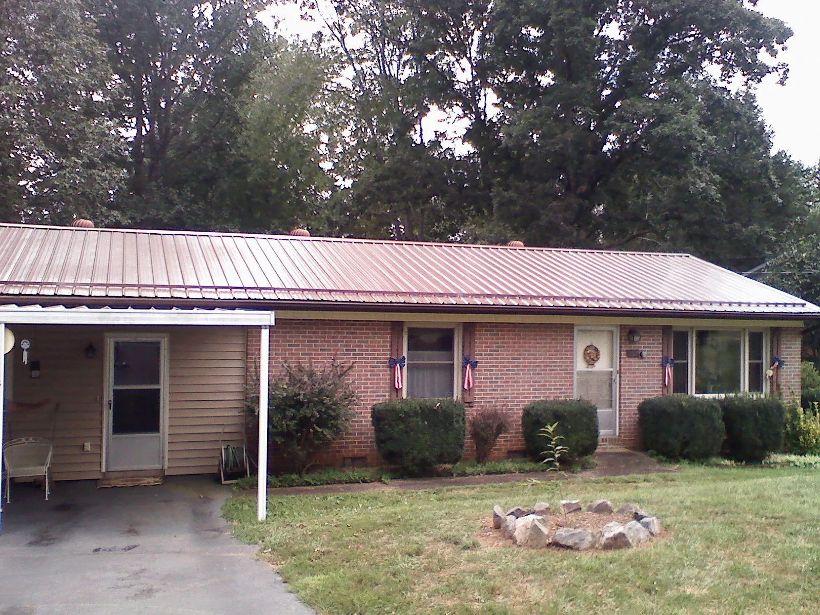 Bronze metal roof and carport on a brick ranch home — Roof Repair work by our crew in Hyannis Port