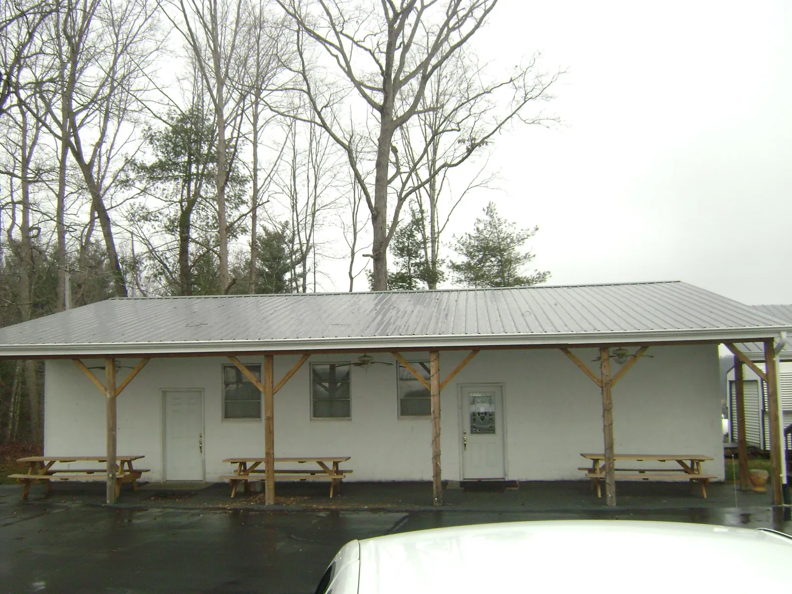 Gray metal roof over a block building with a timber post porch in Hyannis Port